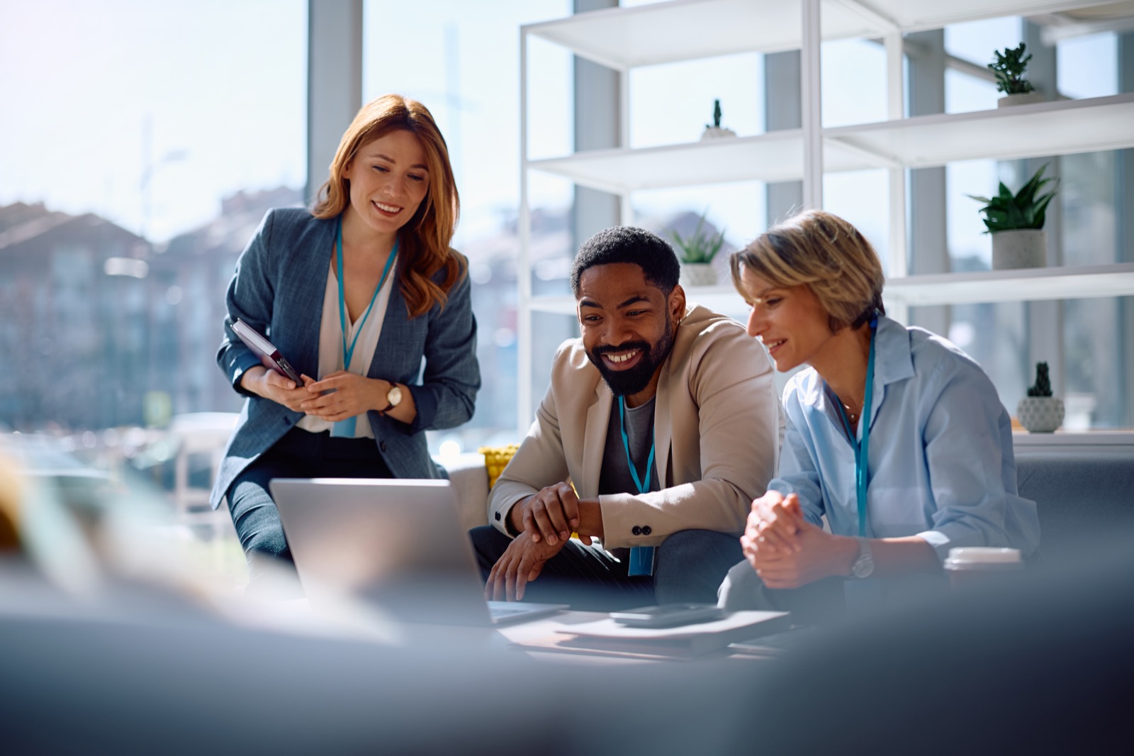 Team members gathered around a laptop, discussing what's on the screen